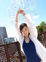 Kana Yuuki in bathsuit plays with umbrella in the balcony